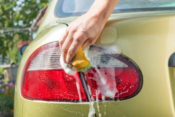 Close-Up of a man washing his car.