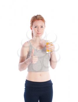 Athletic girl with a glass of juice and a thumbs up on a white background.