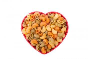 Pasta on the plate in the form of heart on a white background.
