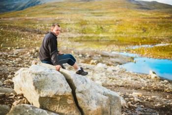 Man Sitting On Stone In Norway Mountains