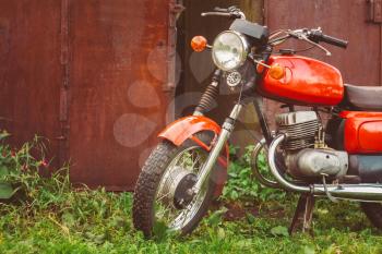 MINSK, BELARUS - SEPTEMBER 22, 2013: Old Red Russian (Soviet) Motorcycle Parked On Green Grass Yard. This motorcycles produced at Degtyarev plant in Russian town Kovrov since 1965.