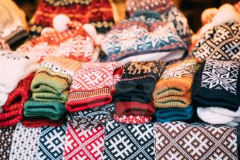 Close View Of Various Colorful Knitted Traditional European Warm Clothes - Caps Hats And Mittens At Winter Christmas Market. Souvenir From Europe.