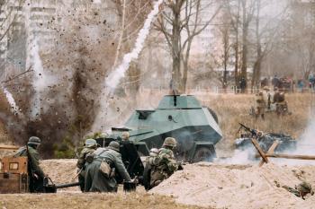 Re-enactors Dressed As German Soldiers In World War II Are Fighting Shooting With A Cannon On The Russian Soviet Armored Car During Historical Reenactment.