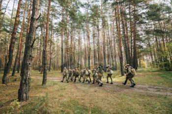 Group Of Re-enactors Dressed As Soviet Russian Red Army Infantry Soldiers Of World War II Marching Along Forest Road At Summer Autumn Season.