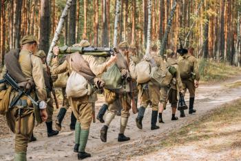 Reenactors Men Dressed As Russian Soviet Red Army Infantry Soldiers Of World War II Marching In Forest With Weapon Machine-gun At Historical Reenactment