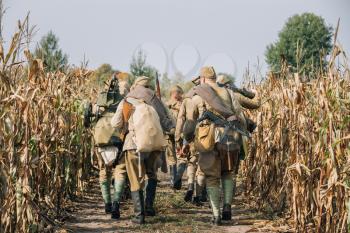 Reenactors Men Dressed As Russian Soviet Red Army Infantry Soldiers Of World War II Marching In Field With Weapon Machine-gun At Historical Reenactment
