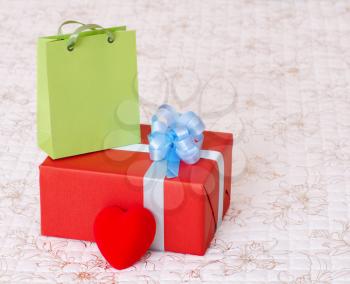 red gift box with a heart and a green bag