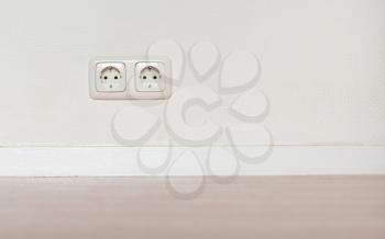 Electrical jack white plastic socket on a white wall