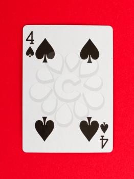 Old playing card (four) isolated on a red background