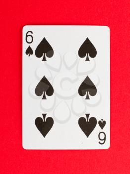 Old playing card (six) isolated on a red background
