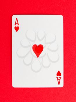 Old playing card (ace) isolated on a red background