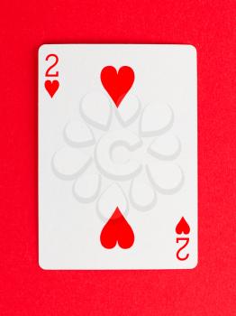 Old playing card (two) isolated on a red background