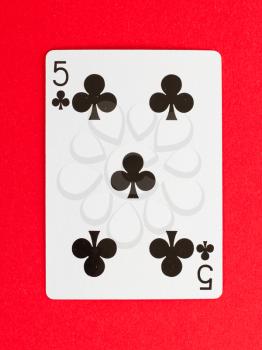 Old playing card (five) isolated on a red background