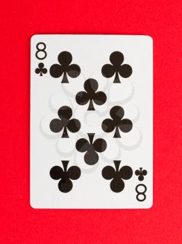 Old playing card (eight) isolated on a red background