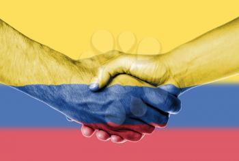 Man and woman shaking hands, wrapped in flag pattern, Colombia