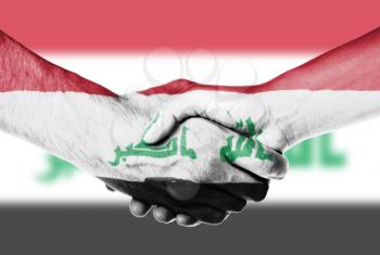 Man and woman shaking hands, wrapped in flag pattern, Iraq