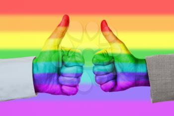 Caucasian business man and woman holding thumb up, rainbow flag