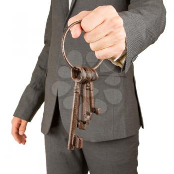Man in grey business suit is holding old rusty keys, isolated