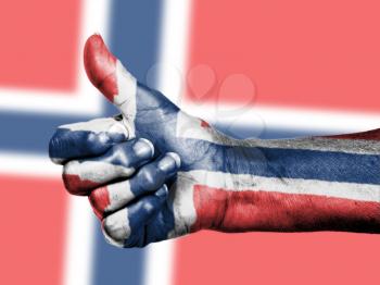 Norwegian flag on thumbs up hand isolated on a flag background