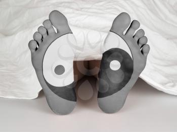 Dead body under a white sheet, concept of sleeping or death, yin yang symbol