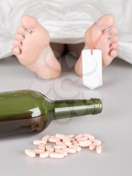 Dead body with toe tag, suicide by drug overdose and alcohol