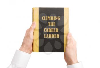 Businessman holding an old book, climbing the career ladder