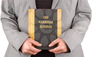 Woman holding a marriage almanac, saving her marriage