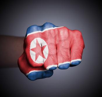 Front view of punching fist on gray background, flag of North Korea