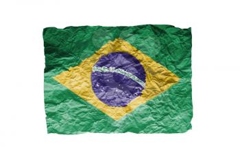 Close up of a curled paper on white background, print of the flag of Brazil