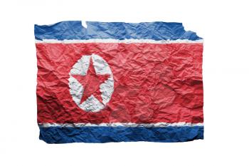 Close up of a curled paper on white background, print of the flag of North Korea