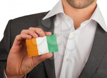 Businessman is holding a business card, flag of Cote d'Ivore