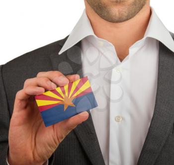 Businessman is holding a business card, flag of Arizona