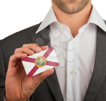 Businessman is holding a business card, flag of Florida