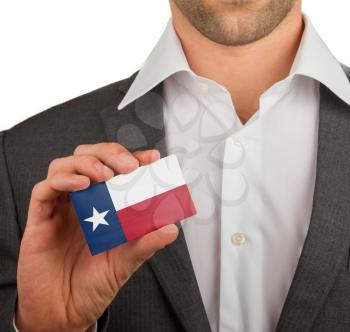 Businessman is holding a business card, flag of Texas