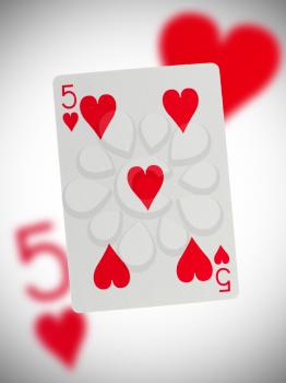 Playing card with a blurry background, five of hearts