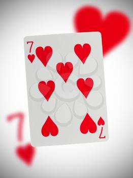 Playing card with a blurry background, seven of hearts