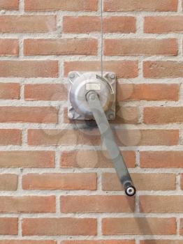 Hand lever winch on a brick wall