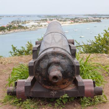 Very old rusted canon pointing at a bay, Caribbean