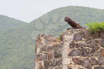 Very old rusted canon on top of an old wall, Caribbean