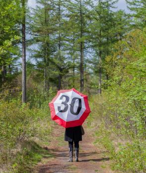 Woman in the forrest with a traffic sign umbrella, Netherlands