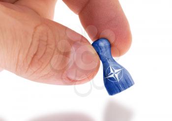 Wooden pawn with a painting of a flag, NATO