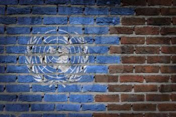 Very old dark red brick wall texture with flag - United Nations
