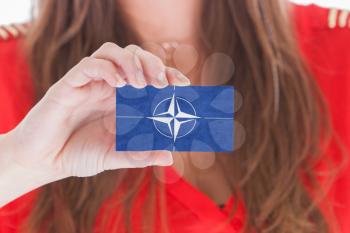 Woman showing a business card, NATO symbol