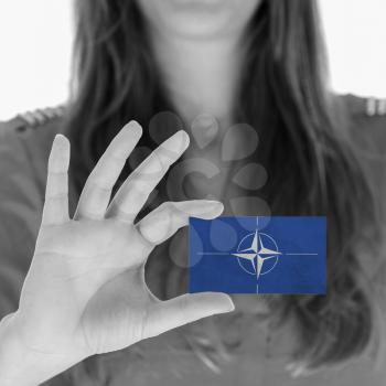 Woman showing a business card, NATO symbol