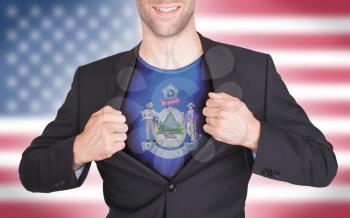 Businessman opening suit to reveal shirt with state flag (USA), Maine
