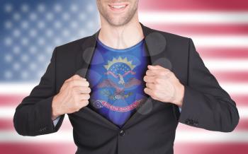 Businessman opening suit to reveal shirt with state flag (USA), North Dakota