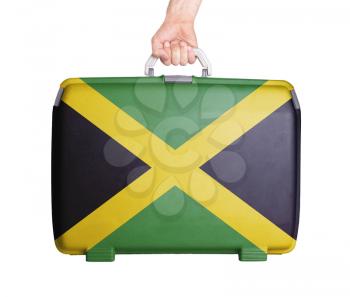 Used plastic suitcase with stains and scratches, printed with flag, Jamaica