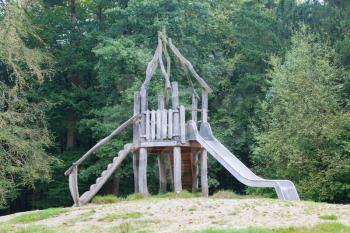 Old wooden playground slide in the middle of a forrest