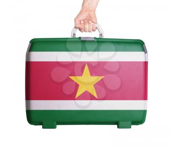 Used plastic suitcase with stains and scratches, printed with flag, Suriname