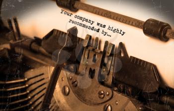 Close-up of an old typewriter with paper, selective focus, your company was highly recommended by